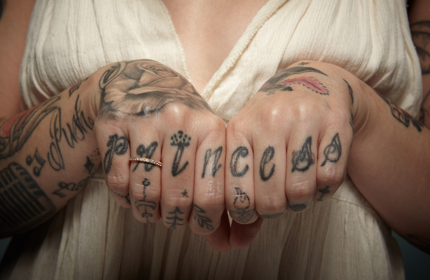 Closeup of Princess Hilla's finger tatoos, spelling out princess