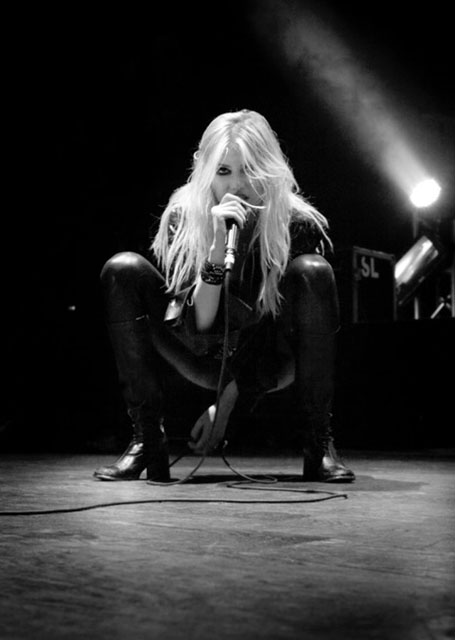 Taylor Momsen crouches on the concert stage